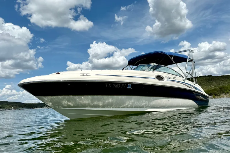 Slide: The Image of 2003 Sea Ray 240 Sundeck boat on calm water under a partly cloudy sky. - 7