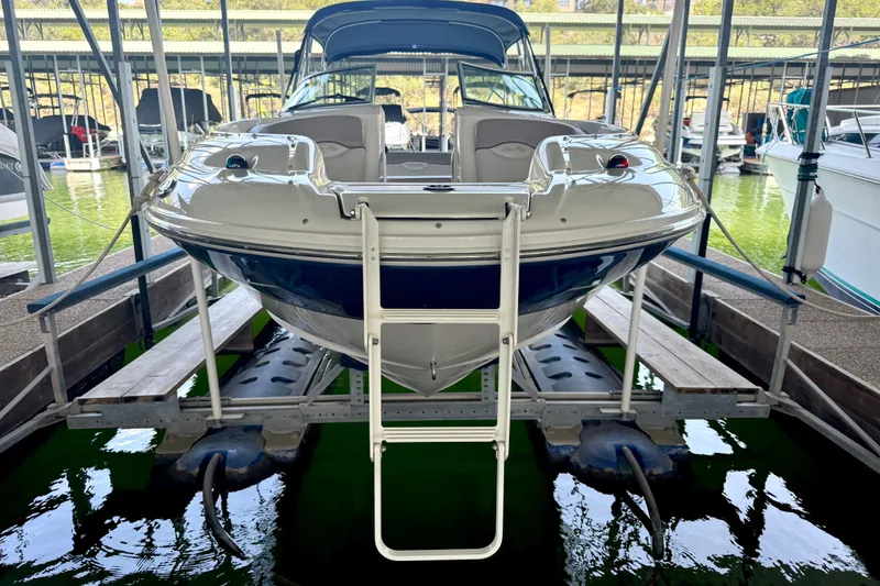 Slide: The Image of 2003 Sea Ray 240 Sundeck boat docked in marina, front view with ladder. - 31