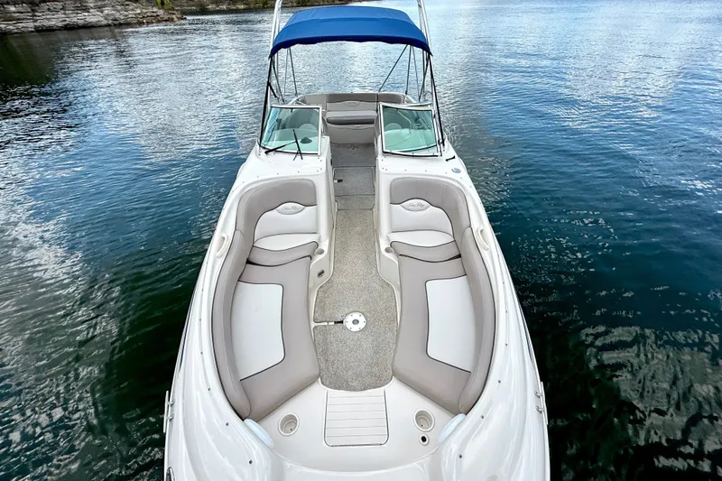 Slide: The Image of 2003 Sea Ray 240 Sundeck boat with spacious seating on calm water. - 18