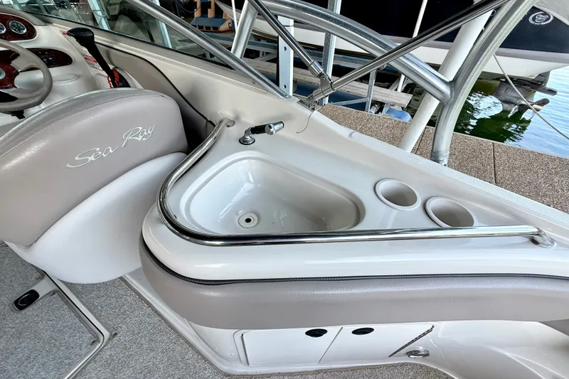 Slide: The Image of 2003 Sea Ray 240 Sundeck interior with sink and cup holders. - 28