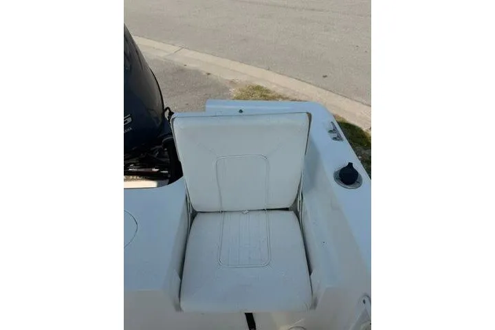 Slide: The Image of 2012 Sea Hunt Triton 177 boat seat with white upholstery and motor in background. - 21