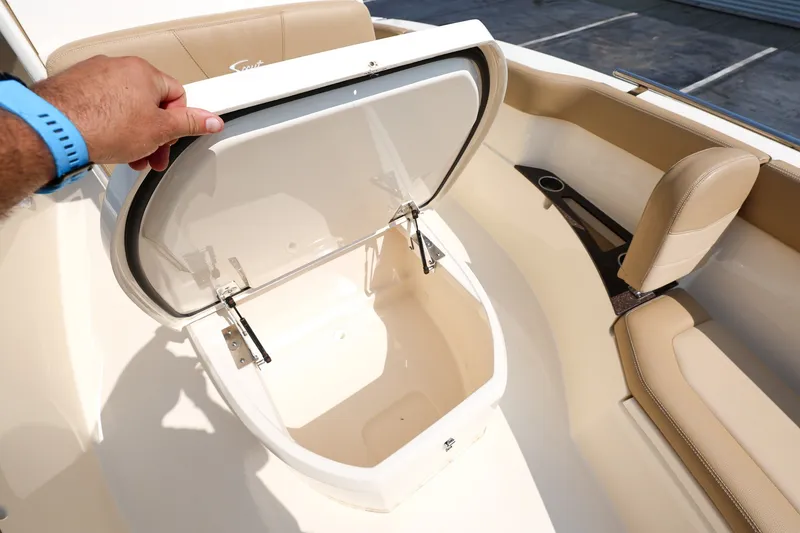 Slide: The Image of 2019 Scout 235 XSF boat storage compartment with beige seating and cup holder. - 18