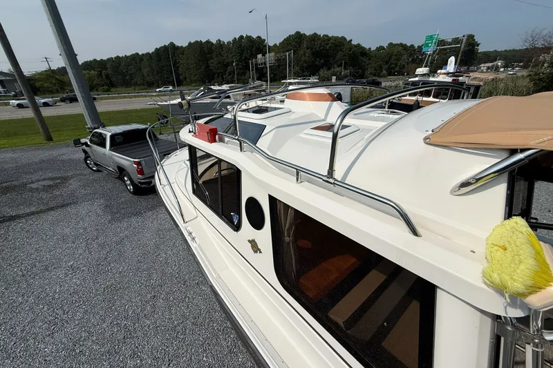 Slide: The Image of 2019 Ranger Tugs R-23 boat hitched to a pickup truck in a parking lot. - 15