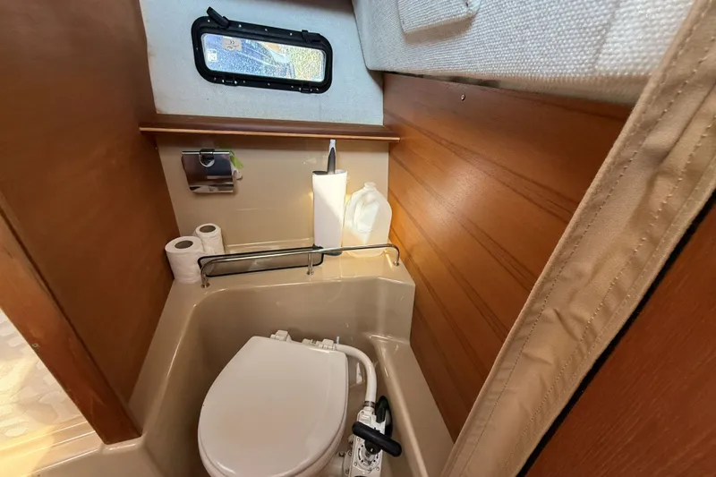 Slide: The Image of Compact bathroom in 2019 Ranger Tugs R-23 boat with toilet and window. - 14