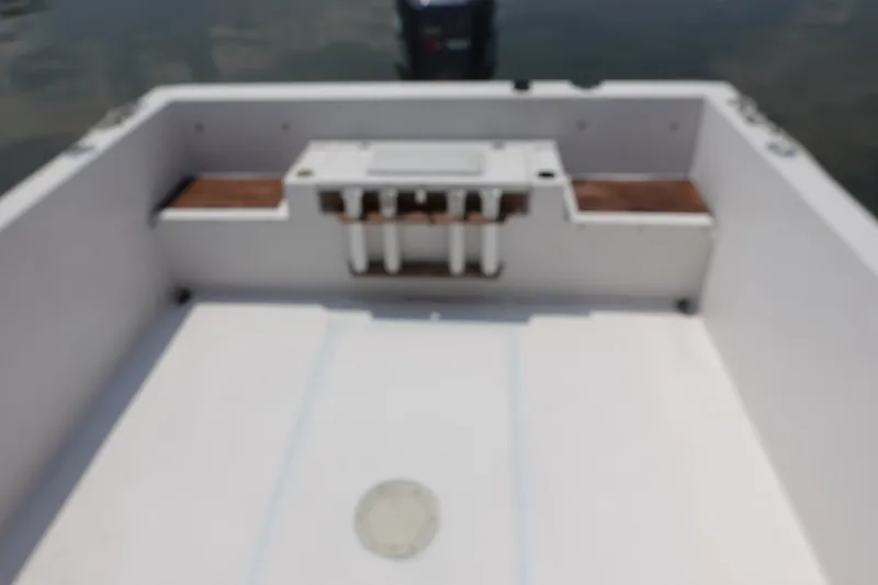 Slide: The Image of 1987 Grady-White Overnighter 206 boat interior with wooden accents and motor in background. - 10