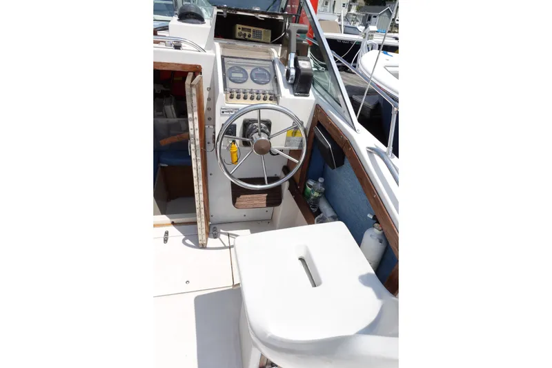 Slide: The Image of 1987 Grady-White Overnighter 206 boat cockpit with steering wheel and control panel. - 6