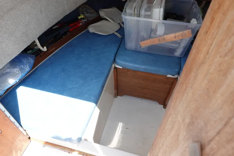 Slide: The Image of Interior cabin of 1987 Grady-White Overnighter 206 with blue cushions and storage box. - 14