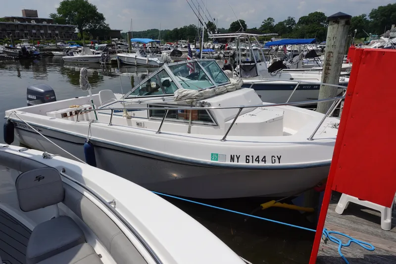 Slide: The Image of 1987 Grady-White Overnighter 206 boat docked at a marina with other vessels. - 2