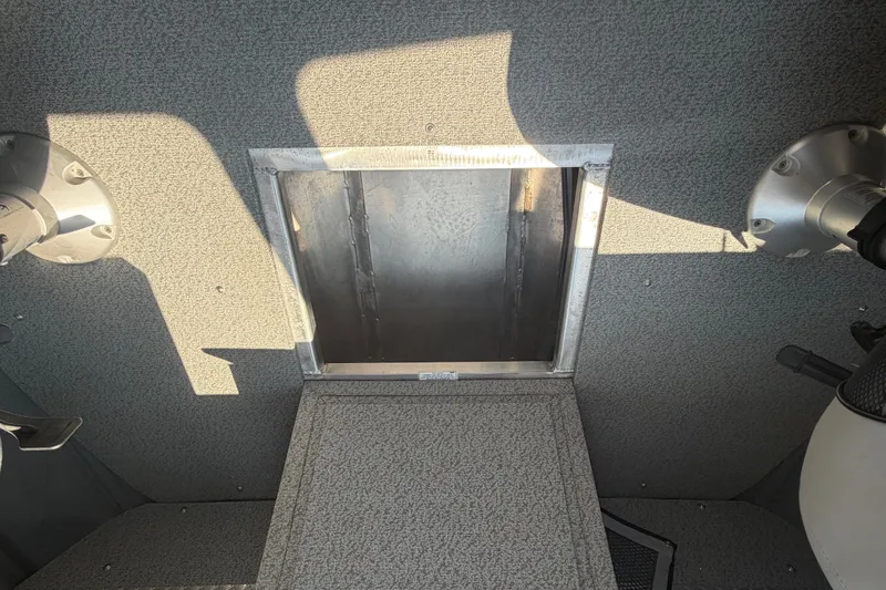 Slide: The Image of Interior view of 2016 Weldcraft 220 Maverick DV boat, featuring a hatch and textured flooring. - 32