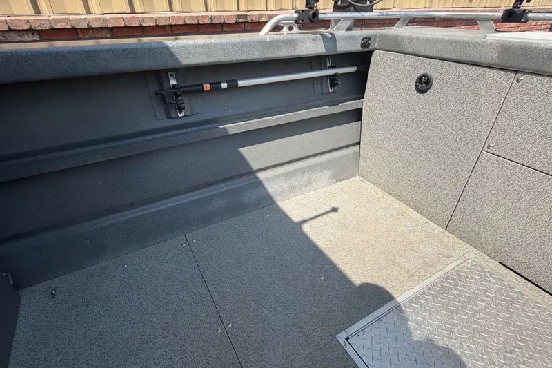 Slide: The Image of Interior view of a 2016 Weldcraft 220 Maverick DV boat, showcasing storage and seating area. - 30