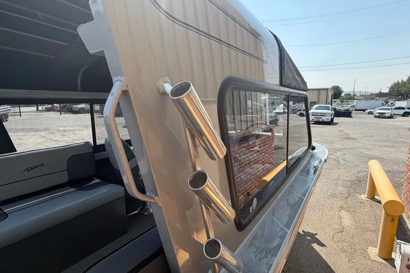 Slide: The Image of 2016 Weldcraft 220 Maverick DV boat with rod holders and seating, parked outdoors. - 23