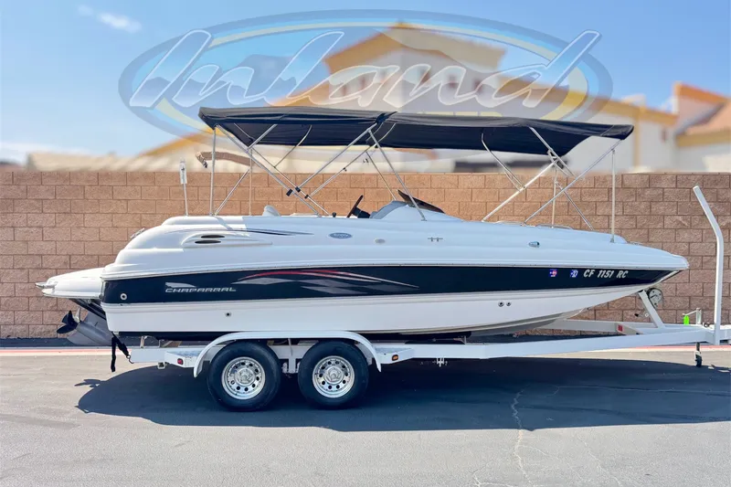 The Image of 2004 Chaparral Sunesta 212 boat on trailer with canopy, parked outdoors. - 0
