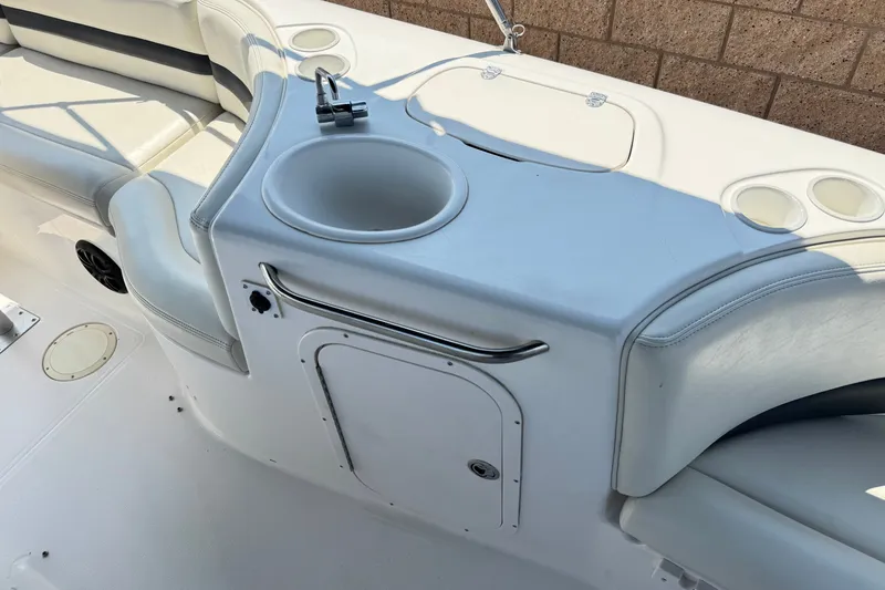 Slide: The Image of 2004 Chaparral Sunesta 212 boat interior with seating, cup holders, and a built-in sink. - 19