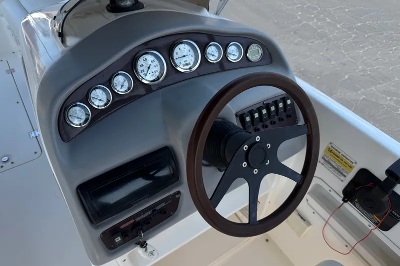 Slide: The Image of 2004 Chaparral Sunesta 212 boat dashboard with gauges and steering wheel. - 27