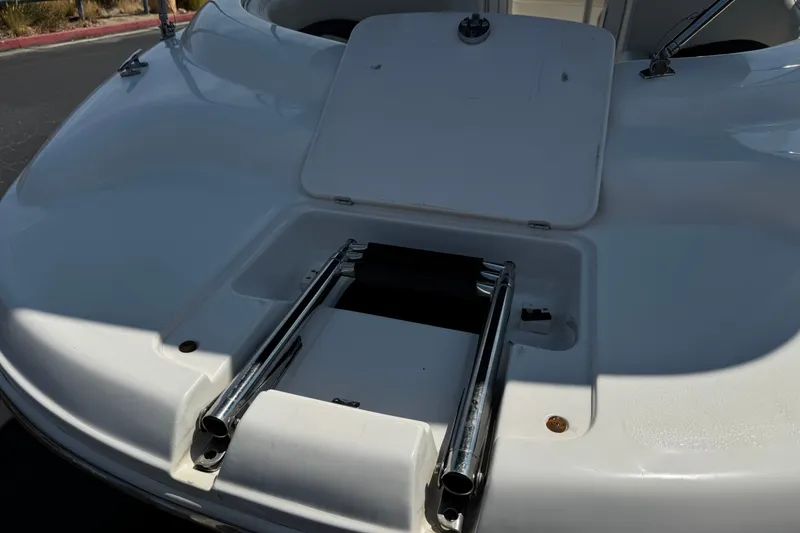 Slide: The Image of 2004 Chaparral Sunesta 212 boat with open storage compartment and ladder. - 11