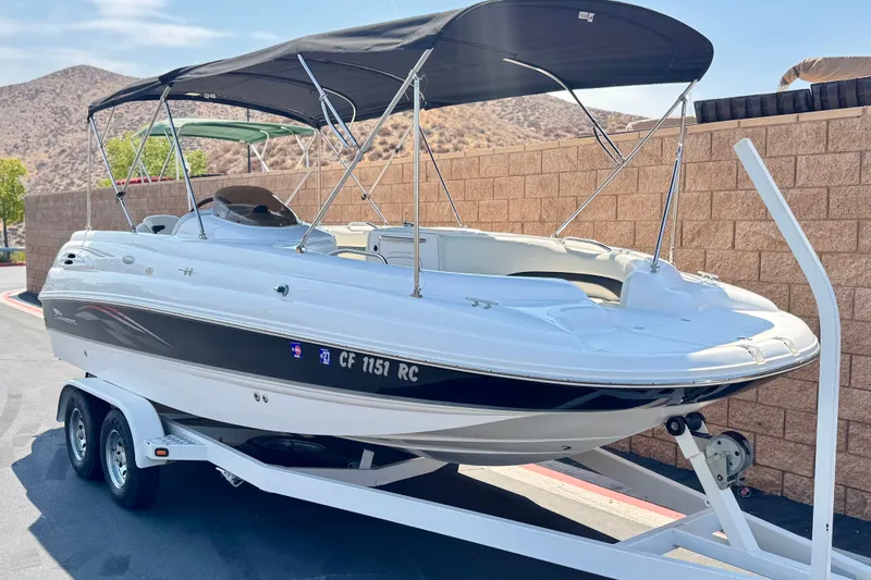 Slide: The Image of 2004 Chaparral Sunesta 212 boat on trailer with canopy, parked near brick wall. - 1
