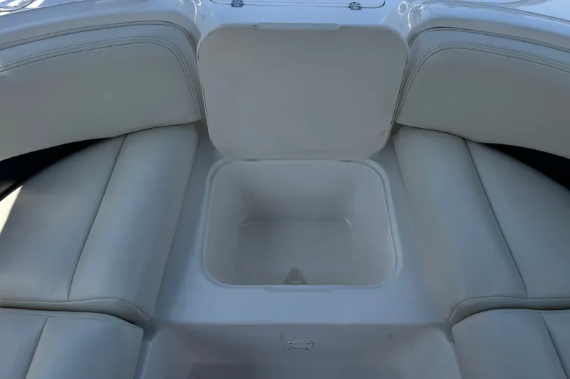 Slide: The Image of 2004 Chaparral Sunesta 212 boat interior with open storage compartment and cushioned seating. - 16