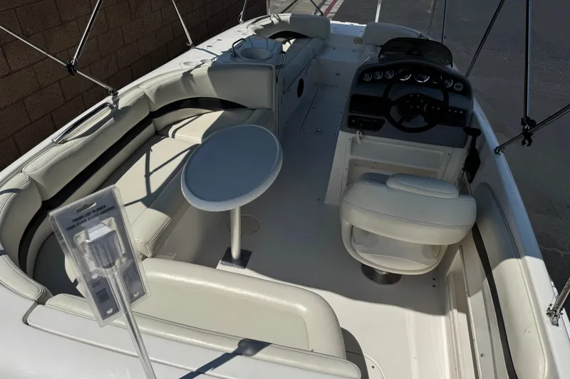 Slide: The Image of 2004 Chaparral Sunesta 212 boat interior with seating, table, and steering console. - 9