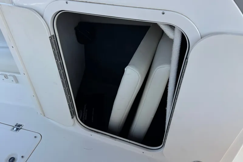 Slide: The Image of Storage compartment on a 2004 Chaparral Sunesta 212 boat with white cushions inside. - 30
