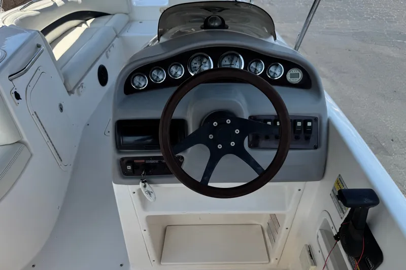 Slide: The Image of 2004 Chaparral Sunesta 212 boat dashboard with steering wheel and gauges. - 26