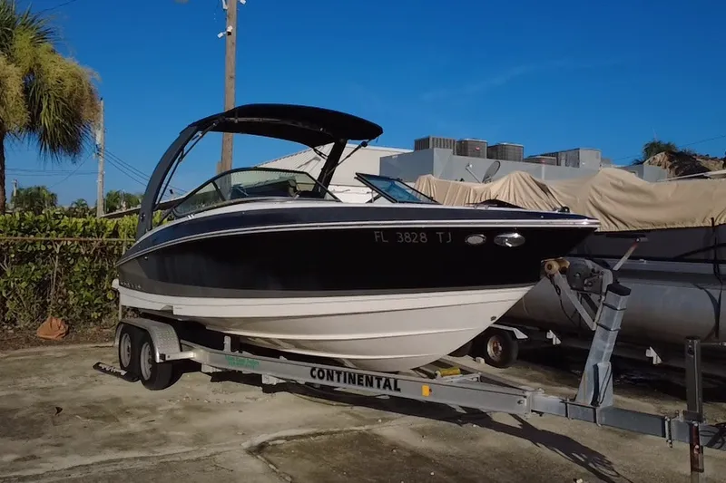 The Image of 2018 Regal 2300 Bowrider on trailer, parked outdoors under clear blue sky. - 0