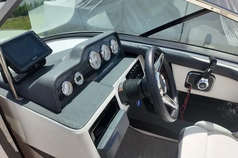 Slide: The Image of 2018 Regal 2300 Bowrider dashboard with steering wheel and gauges in a sleek design. - 14