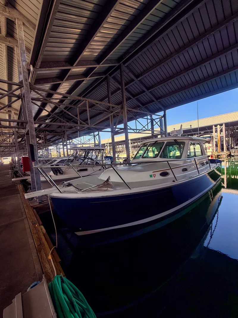 Slide: The Image of A 2016 Back Cove 30 boat is docked in a covered marina. - 31