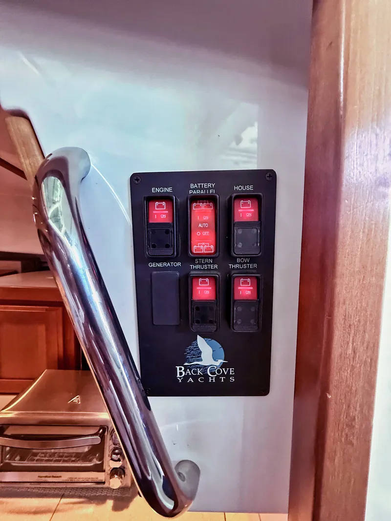Slide: The Image of Control panel with various switches and Back Cove Yachts logo. - 23