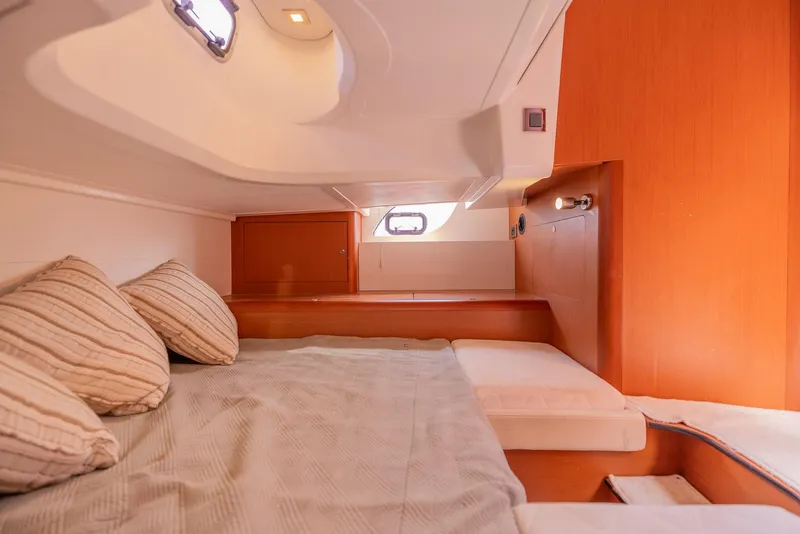 Slide: The Image of Interior cabin of 2013 Beneteau Gran Turismo 38 yacht, featuring cozy bedding and wooden accents. - 36