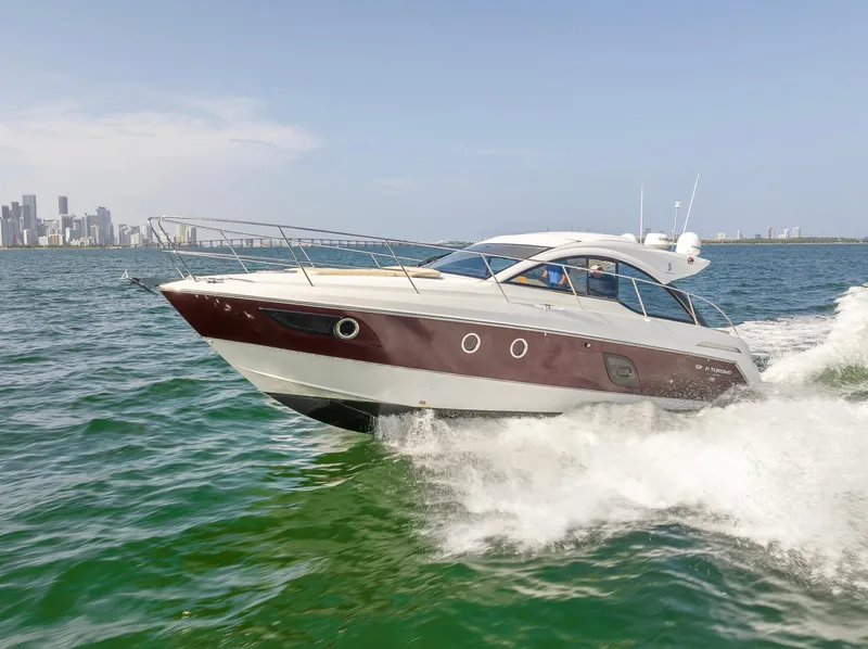 Slide: The Image of 2013 Beneteau Gran Turismo 38 cruising on open water near city skyline. - 1