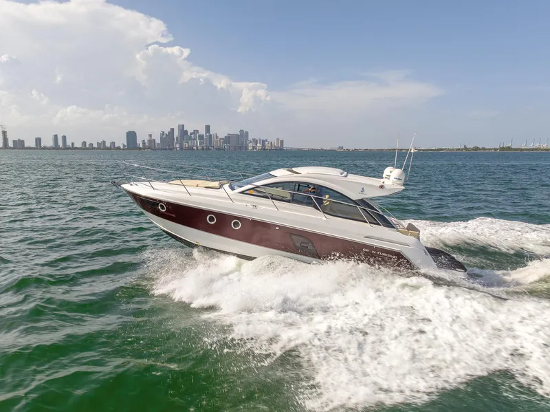 The Image of 2013 Beneteau GRAN TURISMO 38 cruising on open water with city skyline backdrop. - 0