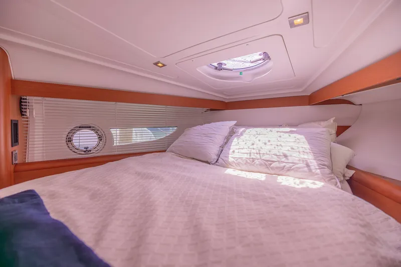 Slide: The Image of Cozy cabin interior of 2013 Beneteau Gran Turismo 38 yacht with bed and porthole. - 34