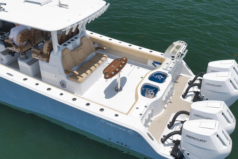 Slide: The Image of 2026 Freeman 42LR boat with Mercury engines, spacious deck, and seating on the water. - 27