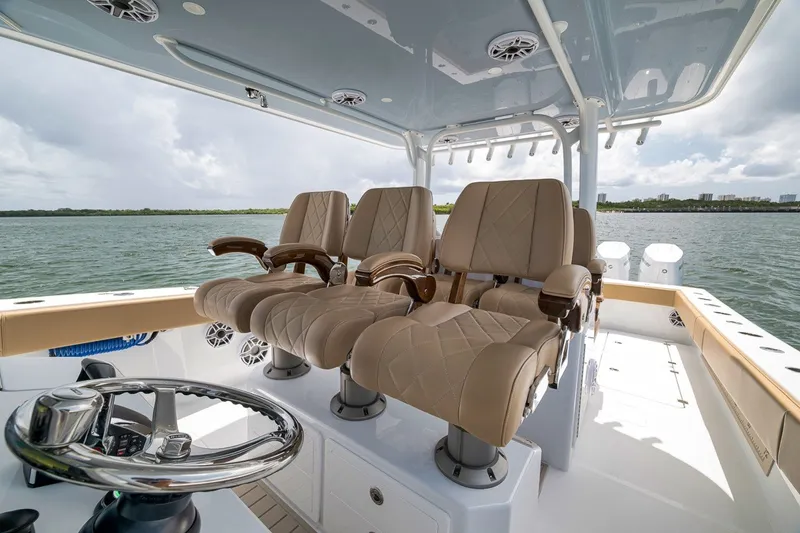 Slide: The Image of Luxury seating on 2026 Freeman 42LR boat, featuring plush, tan captain chairs and sleek design. - 103