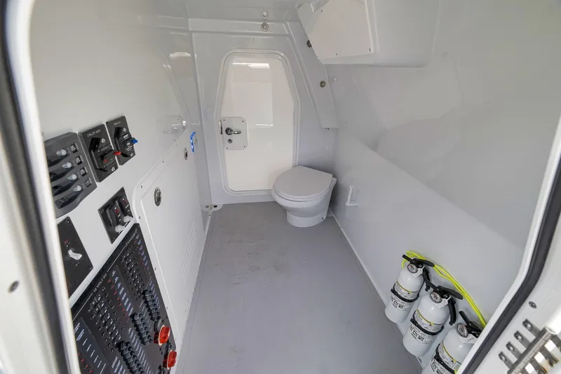 Slide: The Image of Interior of a 2026 Freeman 42LR boat featuring a compact bathroom with control panels. - 117