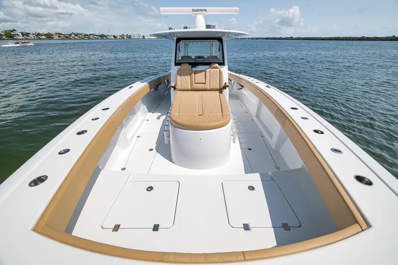 Slide: The Image of Luxurious 2026 Freeman 42LR boat with tan seating, cruising on calm waters. - 54