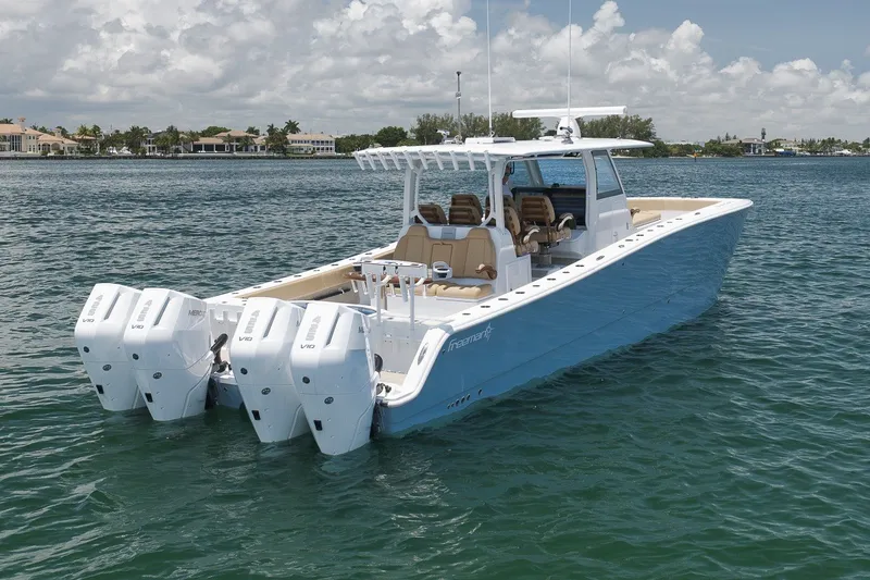 Slide: The Image of 2026 Freeman 42LR boat with quad engines on calm water under a cloudy sky. - 22