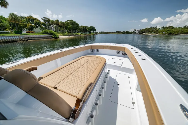 Slide: The Image of Luxurious 2026 Freeman 42LR boat with tan seating, cruising on a serene waterway. - 46