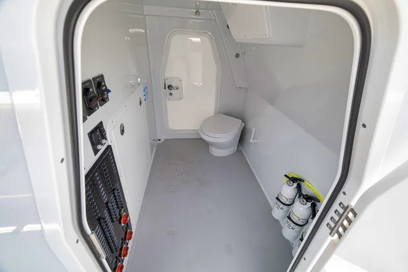 Slide: The Image of Interior of Freeman 42LR 2026 boat featuring a compact bathroom with toilet and control panels. - 116