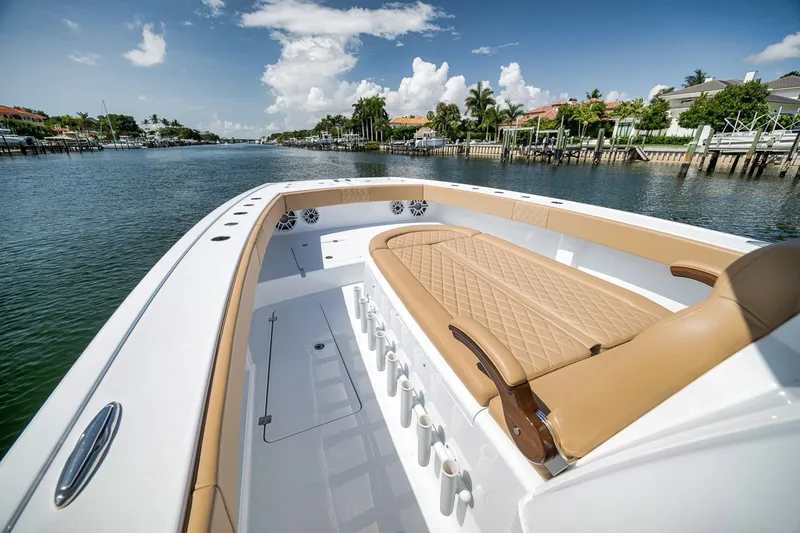 Slide: The Image of Luxurious 2026 Freeman 42LR boat interior with tan seating, docked by a scenic waterfront. - 36