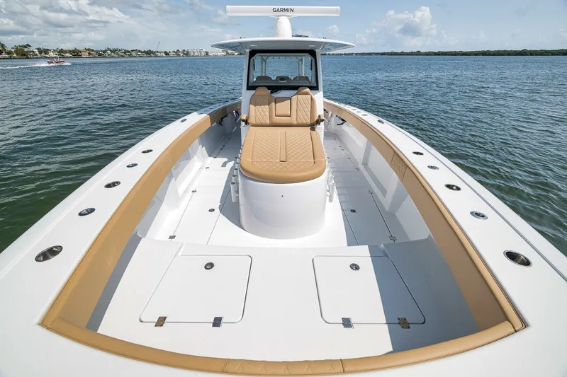 Slide: The Image of 2026 Freeman 42LR boat with tan seating, spacious deck, and Garmin equipment on calm water. - 55