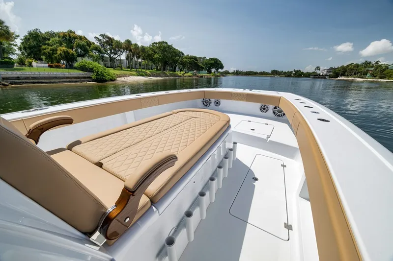 Slide: The Image of Luxurious 2026 Freeman 42LR boat interior with tan seating, cruising on a serene waterway. - 47