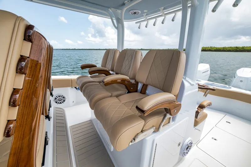 Slide: The Image of Luxurious seating on a 2026 Freeman 42LR boat, featuring tan leather and wooden accents. - 98