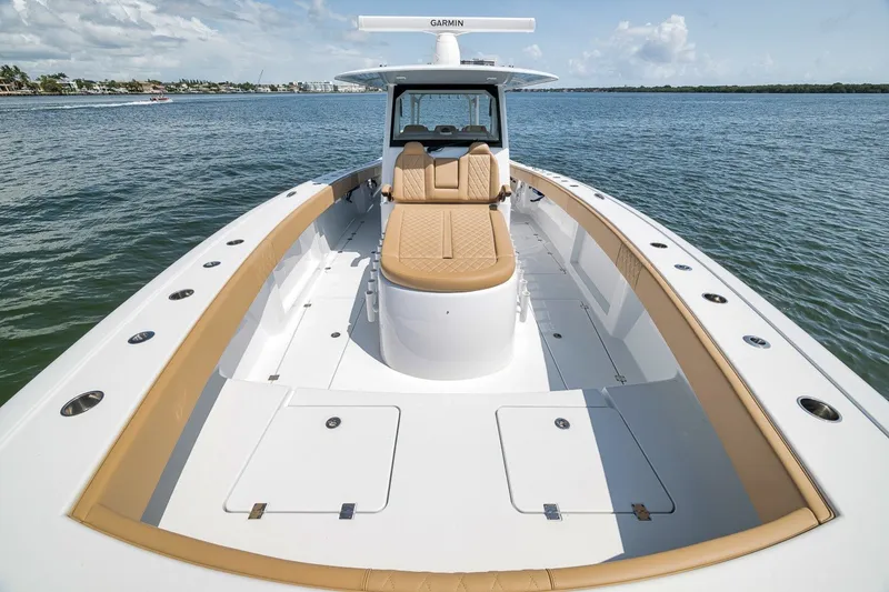 Slide: The Image of 2026 Freeman 42LR boat with tan seating, cruising on calm waters under a clear sky. - 56