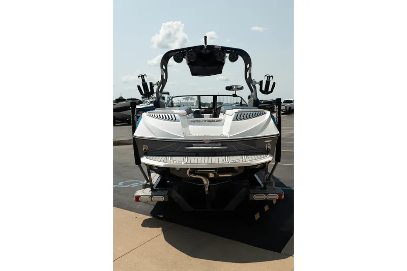 Slide: The Image of 2019 Nautique Super Air Nautique G23 boat, rear view, parked on a trailer under a sunny sky. - 6