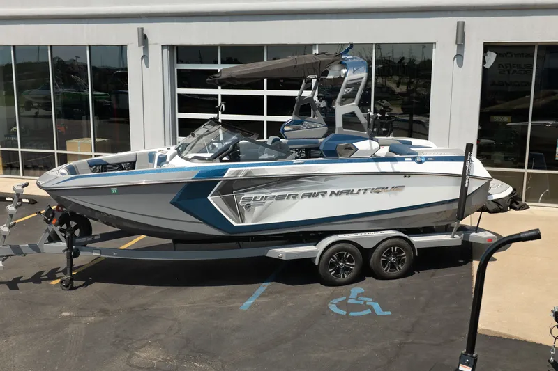 Slide: The Image of 2019 Nautique Super Air Nautique G23 boat on trailer, parked outside a building. - 3