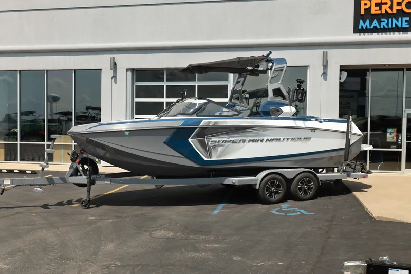 Slide: The Image of 2019 Nautique Super Air Nautique G23 boat on trailer outside marine dealership. - 2