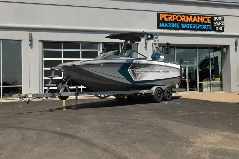The Image of 2019 Nautique Super Air Nautique G23 boat on trailer outside marine dealership. - 1