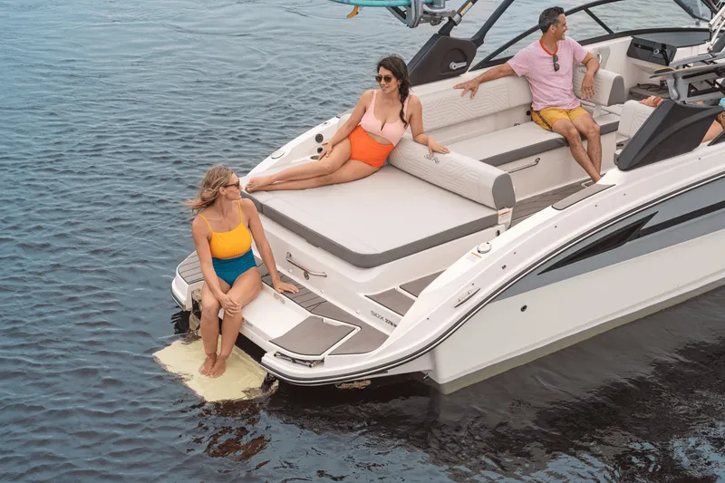 Slide: The Image of Four people relax on a Sea Ray SDX 270 Surf boat on the water. - 28