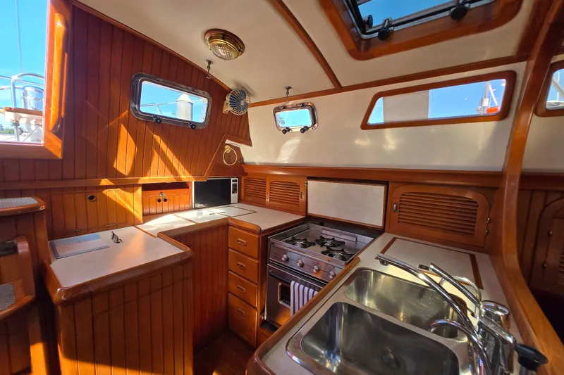 Slide: The Image of 1989 Fair Weather Mariner 39 yacht interior kitchen with wood paneling and modern appliances. - 20